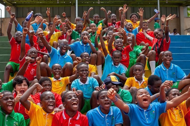MGIS students in house colours cheering from the stands on Sports Day